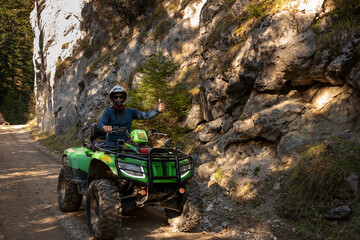 A man on a quad bike in the mountains.