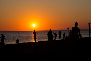 Fototapeta na wymiar people on the seashore during sunset