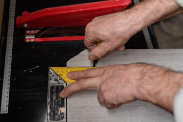 Laying ceramic floor tiles - man hands closeup