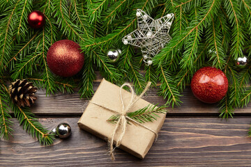 Christmas gift box with fir tree branches on wooden background