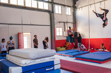The students of the circus school rehearse with the trapezes