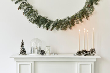 Christmas composition on the white chimney at the living room interior with beautiful decoration....