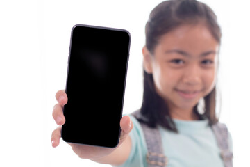 Adorable Asian smart girl in casual playing game or texting to friend on smartphone, happy schoolgirl sit on sofa using phone technology searching information study learn from home social distance
