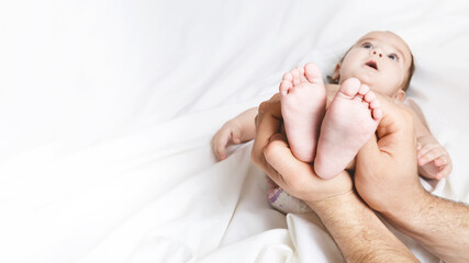 dad is holding the baby's tiny feet. Small baby feet on male hands close up. Happy family concept. Beautiful conceptual image of fatherhood. top view.