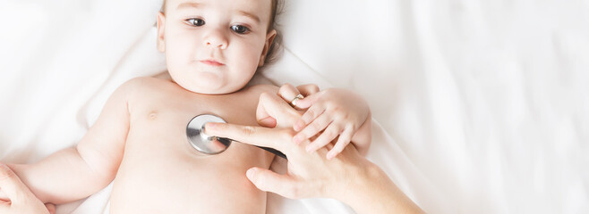 doctor examining baby.A pediatrician examines a girl with a stethoscope, checking his heartbeat. copy space