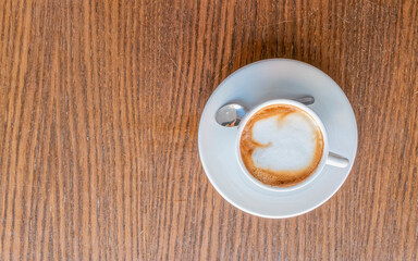 cappuccino coffee cup top vew closeup on wooden table, space for your text