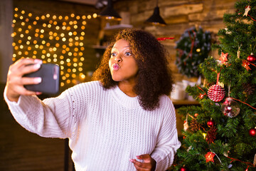 Joyful brazil charming woman talking by video call with her family in cozy room