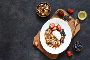 Granola with yogurt, seeds and coconut on a black background.