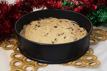 Christmas Cake dough in a cake tin surrounded by tinsel
