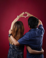 Closeup of couple making heart shape with hands. Couple in love.Focus on hands. 