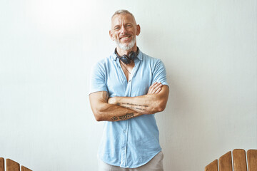 Portrait of a happy middle aged caucasian man keeping arms crossed and smiling at camera while...