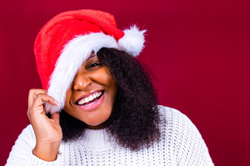 joyful pretty woman in red santa claus hat laughing isolated on red background she is happy and excited full of fun