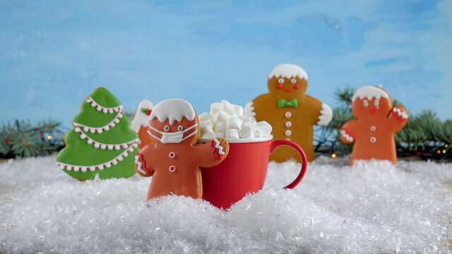Christmas gingerbread. Gingerbread decoration for Christmas. Masked gingerbread man and red marshmallow cup. Shot in 4k