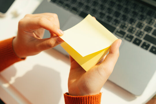 Student opem sticky note for taking note at laptop working desk.