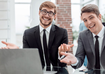 close up. two friendly businessmen sitting at the office Desk