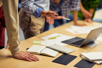 Cropped short of a business people using laptop while working together in the office
