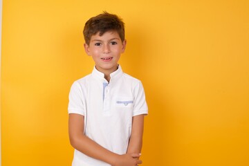 Cute Caucasian little boy standing against yellow background  laughing