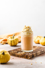 homemade pumpkin and banana smoothie with whipped cream and nuts on top. 