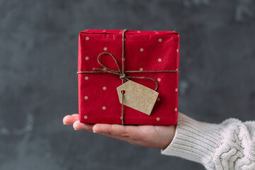 New Year's gift in a red box in the hands of a girl