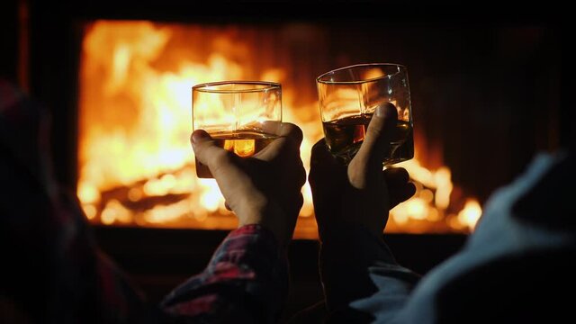 Men's company by the fireplace with glasses of whiskey