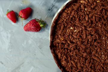 Chocolate cake is decorated with strawberry berries. Homemade cake. Pie on a grey background