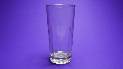 An empty glass kept on purple background