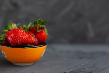 Ripe red strawberries. Bowl filled with juicy fresh ripe red strawberries. strawberries on a grey concrete table. Fresh strawberries photo. Сoncept healthy food