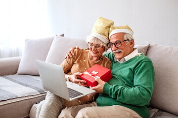 Аn elderly family talking to their children and grandchildren and keeping a distance, during COVID-19. Senior couple at home having a celebration on a video call