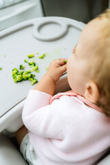 baby eating broccoli with hands, stages of baby-led weaning