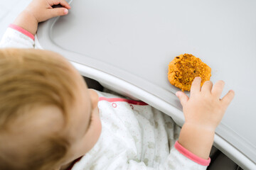 baby eating with his hands at early stages of baby led weaning