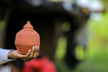 Clay piggy bank holding in hand