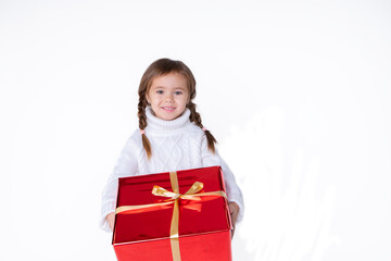 Beautiful little girl in sweater holding christmas present