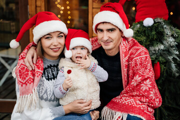 Fototapeta na wymiar A family in Christmas hats on the doorstep.
