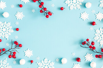 Christmas or winter composition. Snowflakes and red berries on blue background. Christmas, winter, new year concept. Flat lay, top view, copy space - 391756237