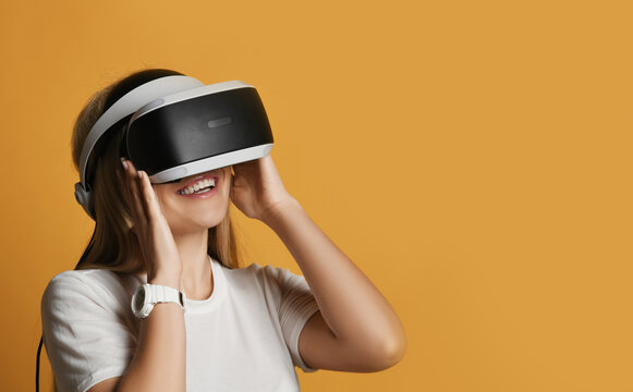 Young blonde woman has fun using virtual reality game wearing uses vr glasses. Woman in cyber space and virtual gaming
