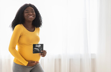 Pregnant black woman showing her baby sonography