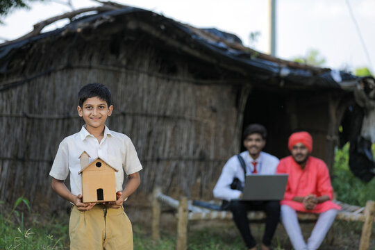 Dream Home Concept : Poor Farmer Little Child Holding Handmade Home In Hand