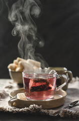 a cup of tea with steam and a bowl with waffles. 