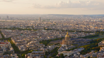 Stunning aerial panorama view of the dense historic center of Paris, France, with famous cathedral of Les Invalides and monument Arc de Triomphe in the beautiful evening sunlight in autumn.