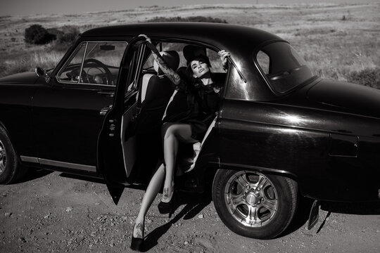 Gorgeous young Latino woman half lying on the passenger seat of her retro car enjoying the sunlight