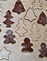Christmas cookie dough stretched and cut with molds in the shape of a gingerbread man, stars and trees