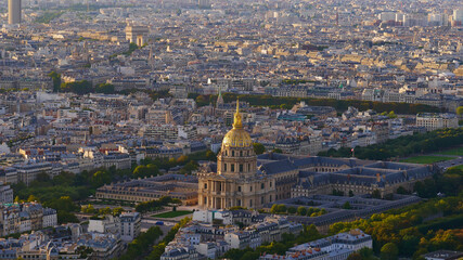 Fototapeta na wymiar Majestic aerial panoramic view of the dense historic center of Paris, France, with Les Invalides complex (Hôtel national des Invalides) and monument Arc de Triomphe in the beautiful evening sunlight.