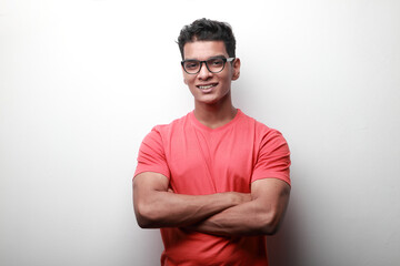 Fototapeta premium Confident smiling young man of Indian origin with folded hands