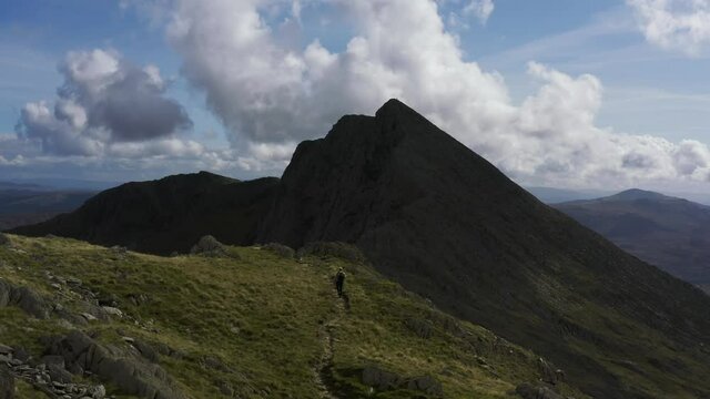 A man walking a spectacular mountain trail in Snowdonia National Park North Wales