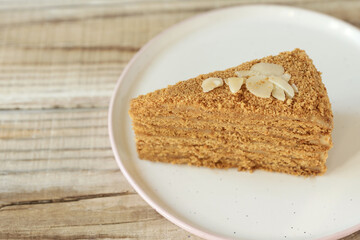 a piece of honey cake on a plate on a wooden table