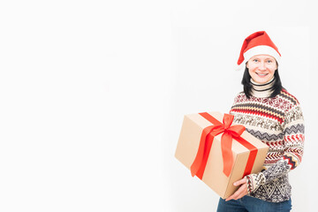 Woman courier in santa hat and christmas sweater holding gift on light background