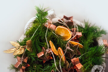 Details of Christmas tree decor in gold close-up and copy space. Christmas tree branches and yellow toys with empty space. New Year 2021.