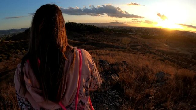Woman hiking at mountain top in nature against cityscape of murcia and Monteagudo Christ in Spain