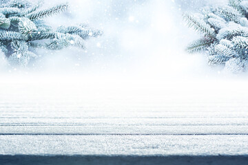 Empty frosty wooden boards with fir branches and snowfall. Atmospähric winter background with...