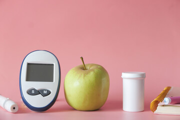  diabetic measurement tools, apple on pink background 
